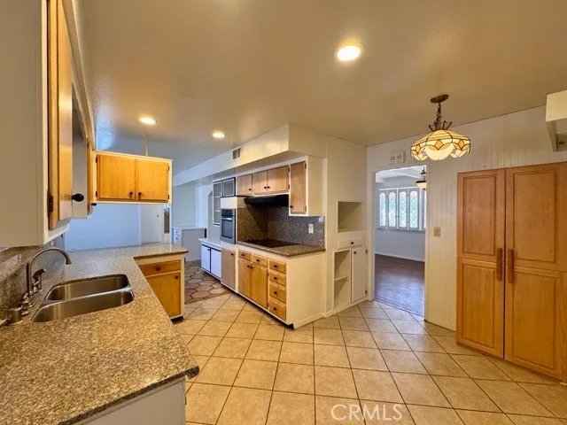 a kitchen with a sink a counter top space appliances and cabinets
