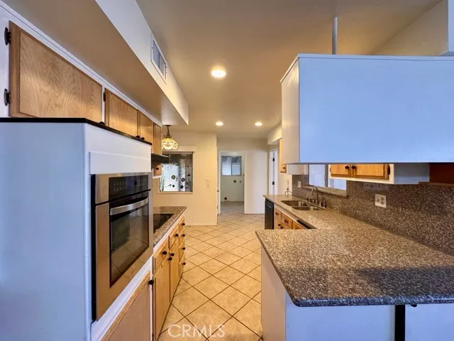 a kitchen with stainless steel appliances granite countertop a sink a stove and a refrigerator