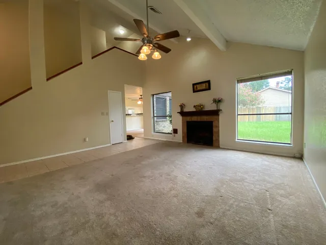 an empty room with windows and fireplace