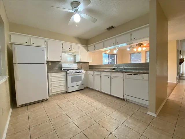 a kitchen with granite countertop a stove sink and cabinets