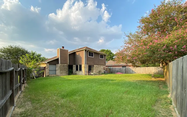 a view of a house with a big yard and a large tree