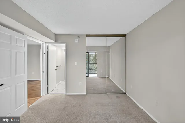 a view of an empty room with window and bathroom