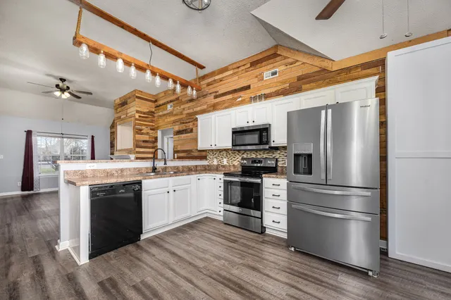 a kitchen with stainless steel appliances a stove microwave and a refrigerator