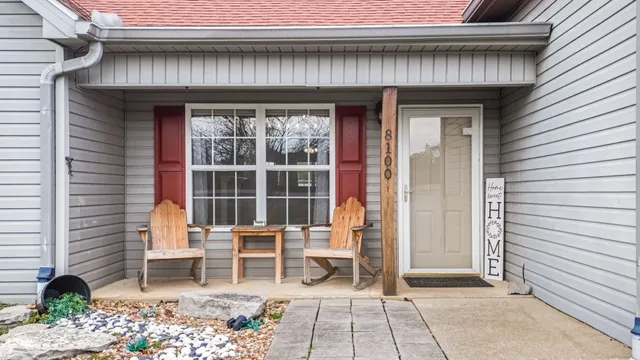 a porch with a table and chairs