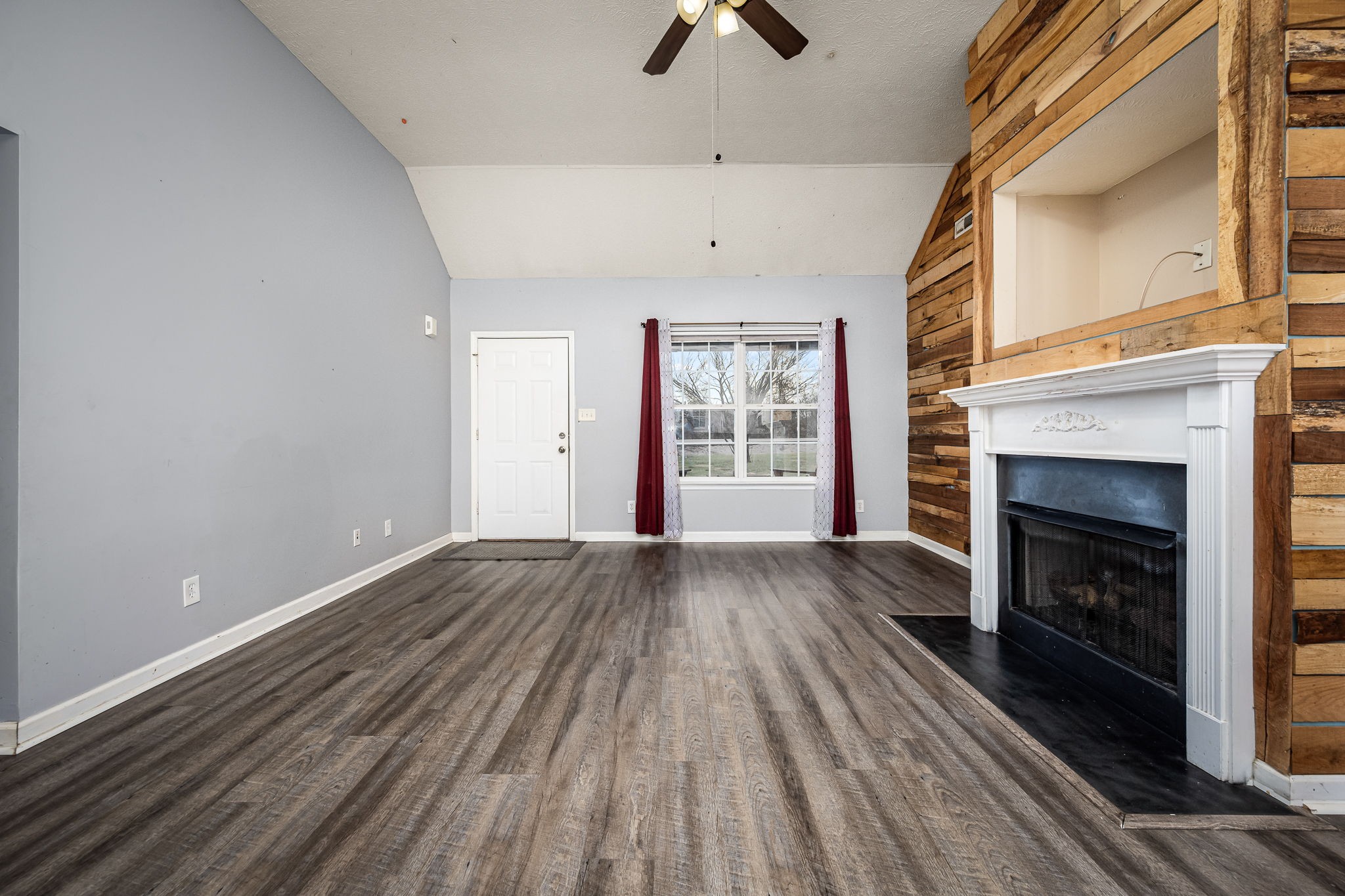 8100 Cedar Forest Road Lascassas, TN 37085 - Photo 10 of 52 a view of an empty room with wooden floor fireplace and a window