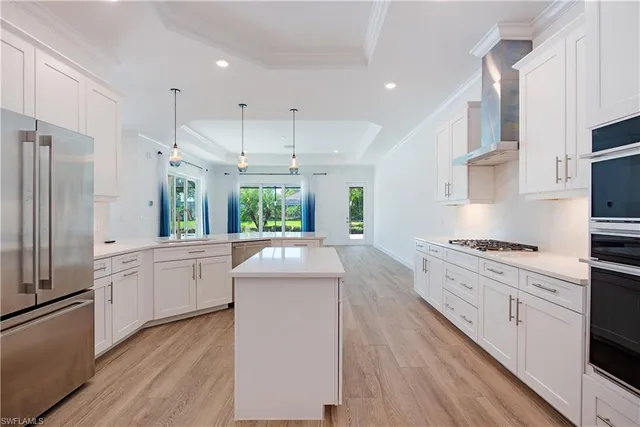 a large kitchen with stainless steel appliances kitchen island granite countertop a stove a sink dishwasher and a refrigerator