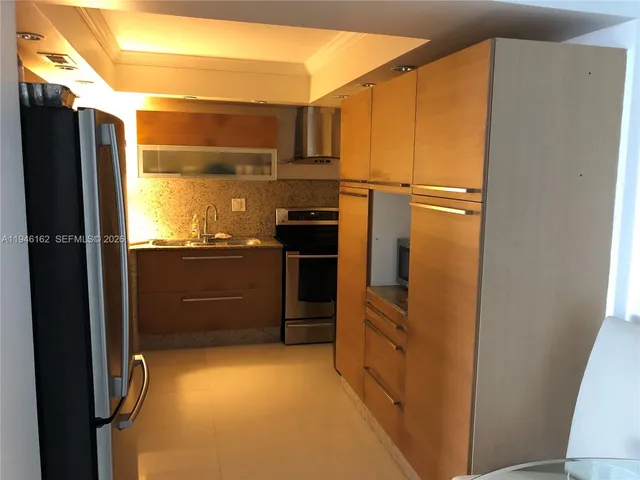 a kitchen with kitchen island and a refrigerator