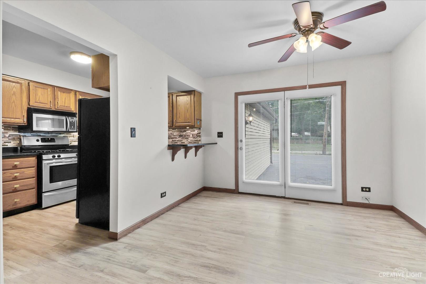 150 Eagle Point Road, Unit J Fox Lake, IL 60020 - Photo 6 of 16 a view of a kitchen with an empty room and wooden floor
