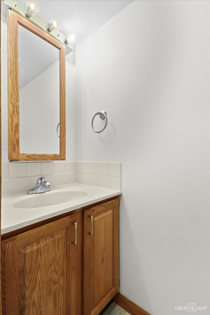 150 Eagle Point Road, Unit J Fox Lake, IL 60020 - Photo 9 of 16 a bathroom with a sink and a mirror