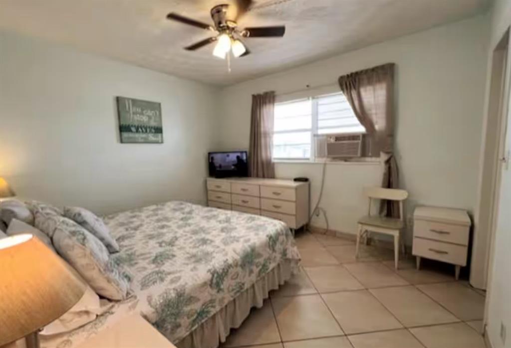 120 Northeast 20th Avenue, Unit 30 Deerfield Beach, FL 33441 - Photo 7 of 14 a bedroom with a bed and a chandelier