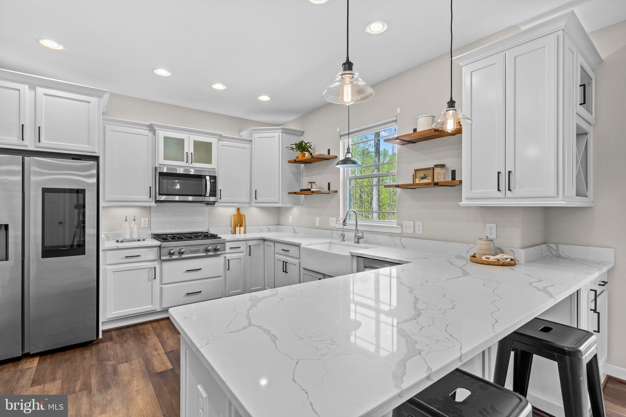 7195 Compass Court King George, VA 22485 - Photo 4 of 58 a kitchen with stainless steel appliances granite countertop a sink stove and refrigerator