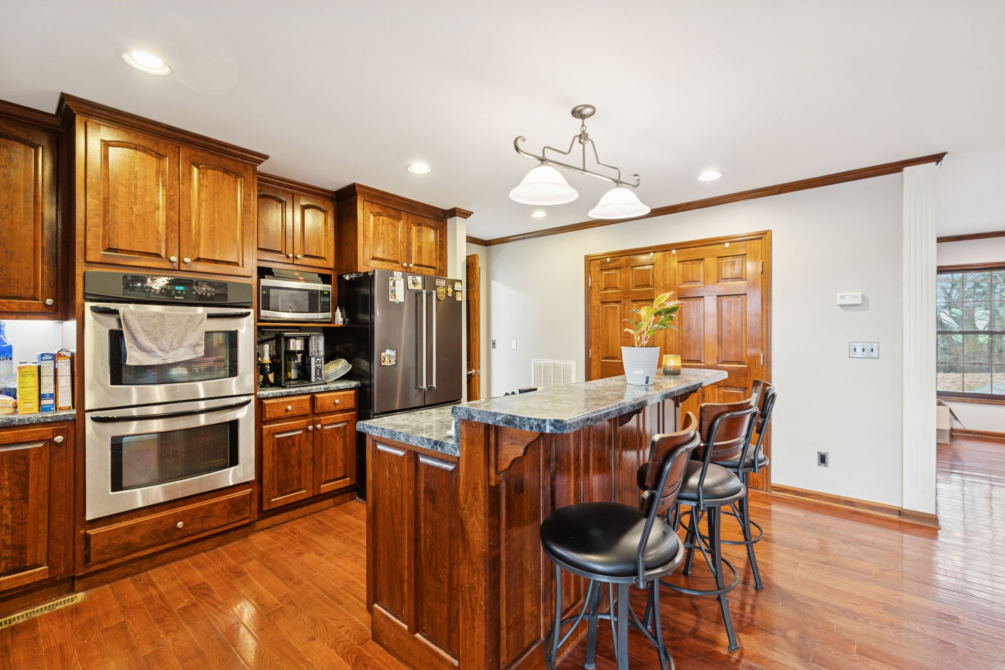 516 Rhotons Chapel Road Manchester, TN 37355 - Photo 16 of 55 a kitchen with stainless steel appliances kitchen island granite countertop a table chairs in it and wooden floors