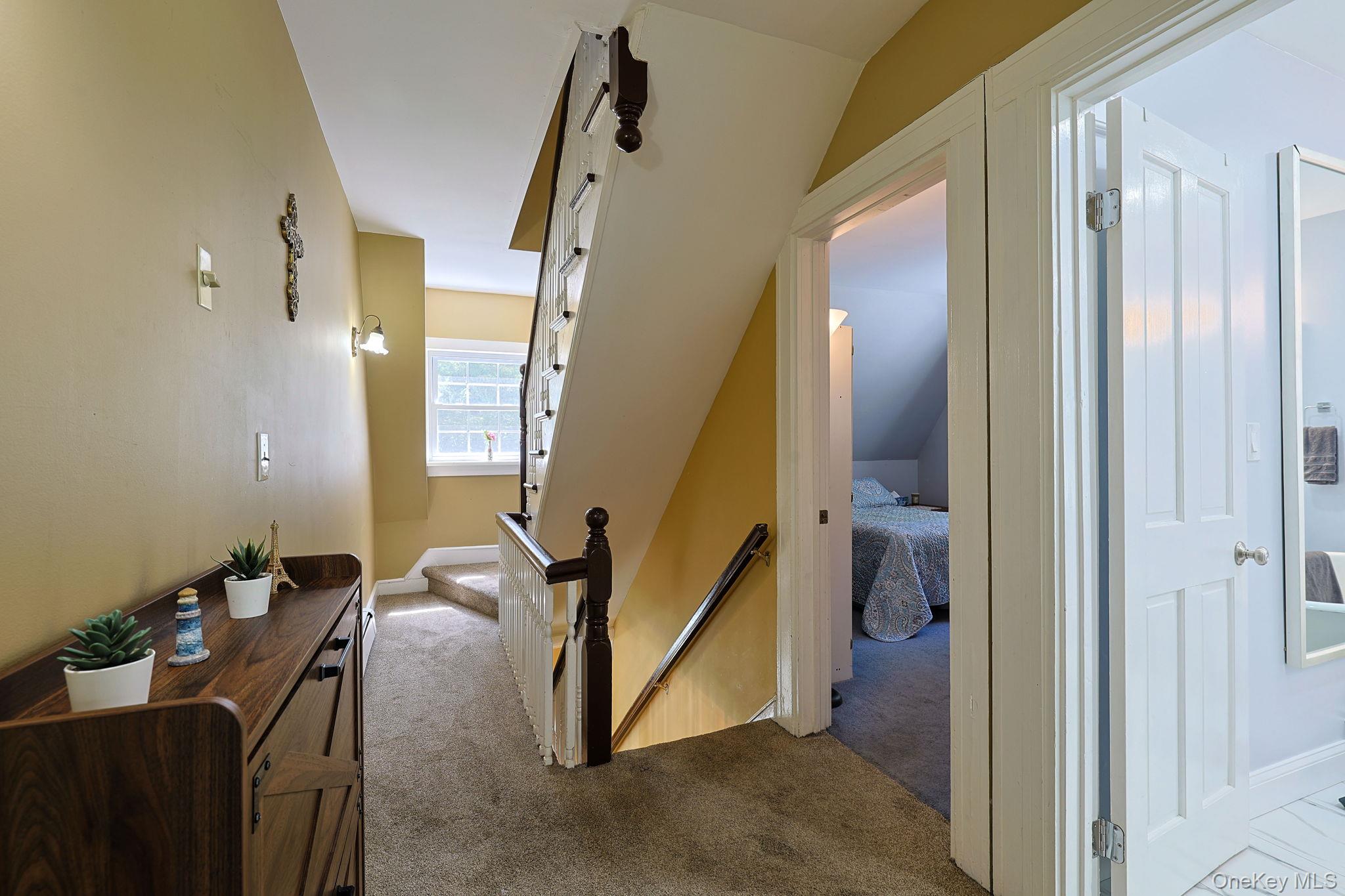 9 Library Road Tuxedo Park, NY 10987 - Photo 21 of 37 Carpeted hallway featuring a wood-finish console table, sconce lighting, and white trim