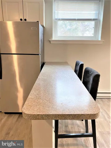 a close view of a refrigerator in kitchen and wooden floor