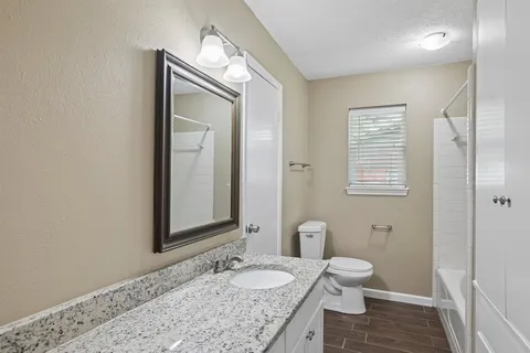 a bathroom with a granite countertop sink toilet and shower