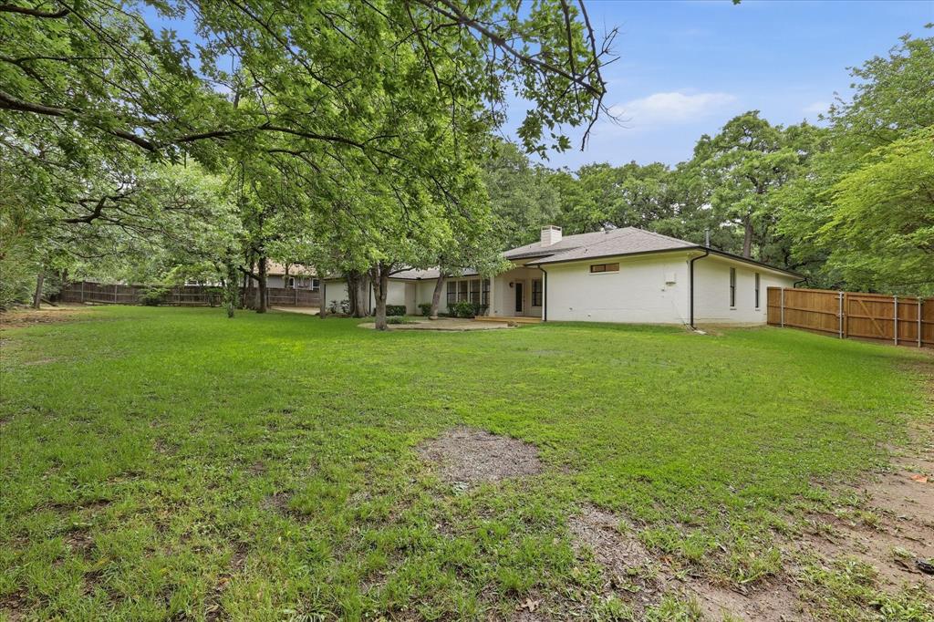 19 Timbergreen Circle Denton, TX 76205 - Photo 38 of 40 a white house that has a big yard with wooden fence