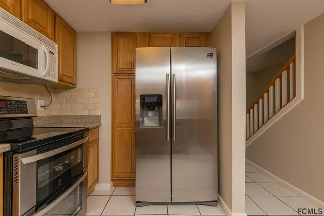 a kitchen with stainless steel appliances granite countertop a refrigerator and a stove top oven