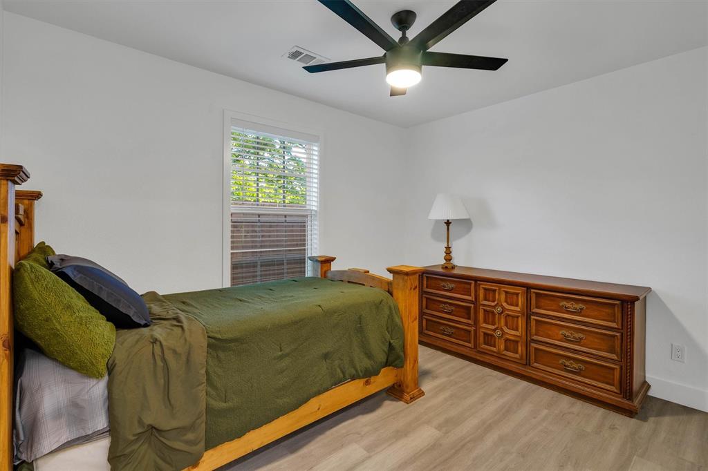 801 Southeast 4th Street Cooper, TX 75432 - Photo 26 of 37 a bedroom with a bed and a chandelier