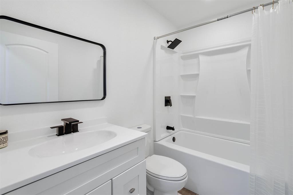 801 Southeast 4th Street Cooper, TX 75432 - Photo 27 of 37 a bathroom with a bathtub shower sink vanity mirror and toilet