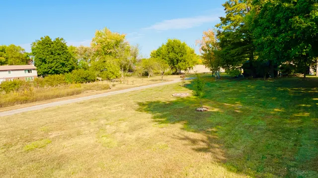 a view of yard with swimming pool and trees in the background