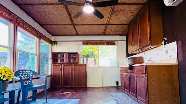 a open kitchen with granite countertop a stove top oven a sink with wooden cabinets and floor