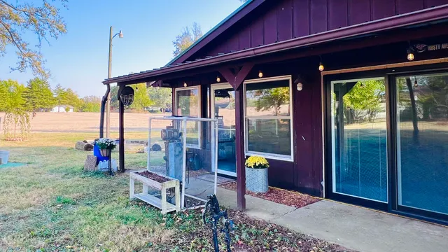 a view of backyard with a barn and a large tree