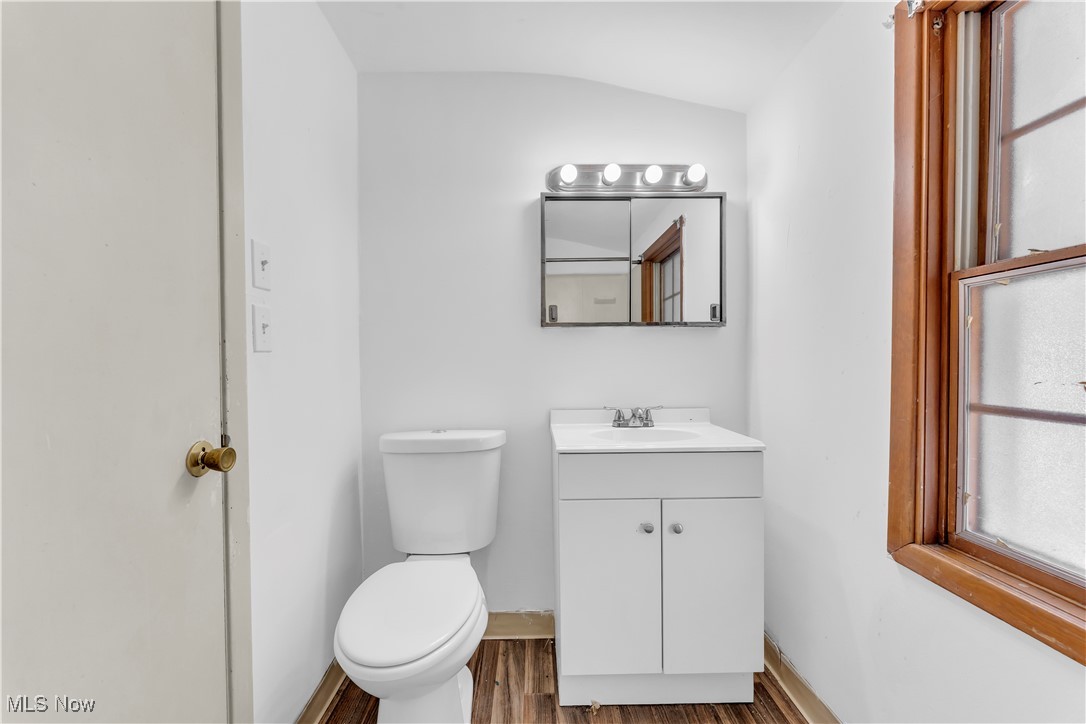 5817 Turney Road Garfield Heights, OH 44125 - Photo 23 of 31 Half bathroom featuring vanity, wood finished floors, and vaulted ceiling