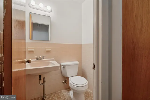 a bathroom with a sink toilet and mirror