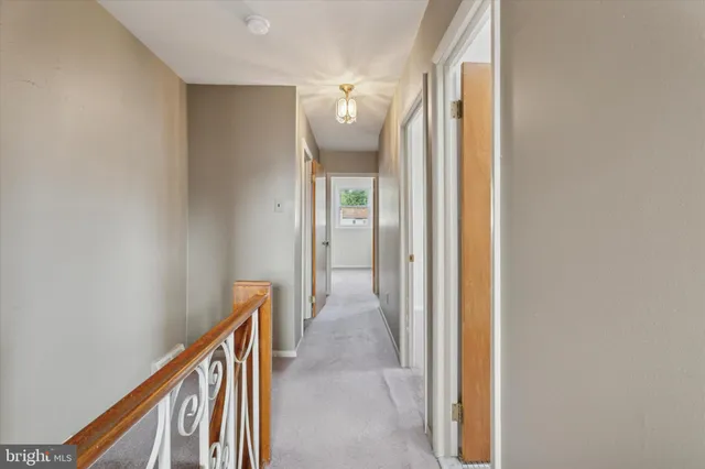 a view of a hallway with wooden floor and stairs