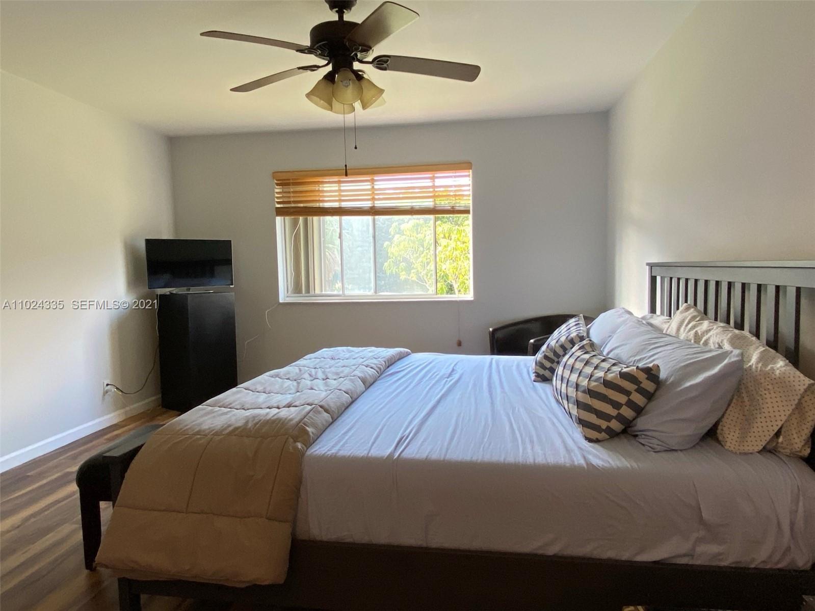 209 Lakeview Drive, Unit 202 Weston, FL 33326 - Photo 13 of 25 a bedroom with a bed and wooden floor