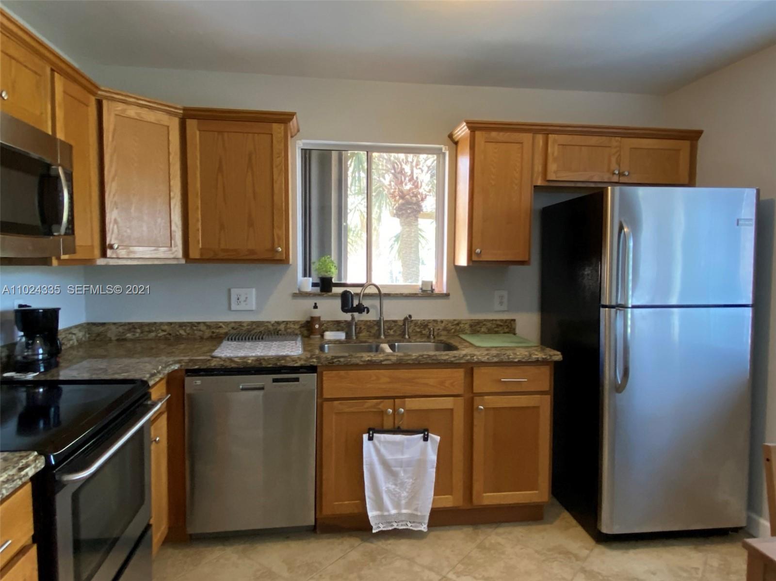 209 Lakeview Drive, Unit 202 Weston, FL 33326 - Photo 17 of 25 a kitchen with stainless steel appliances granite countertop a refrigerator a stove a sink and a microwave