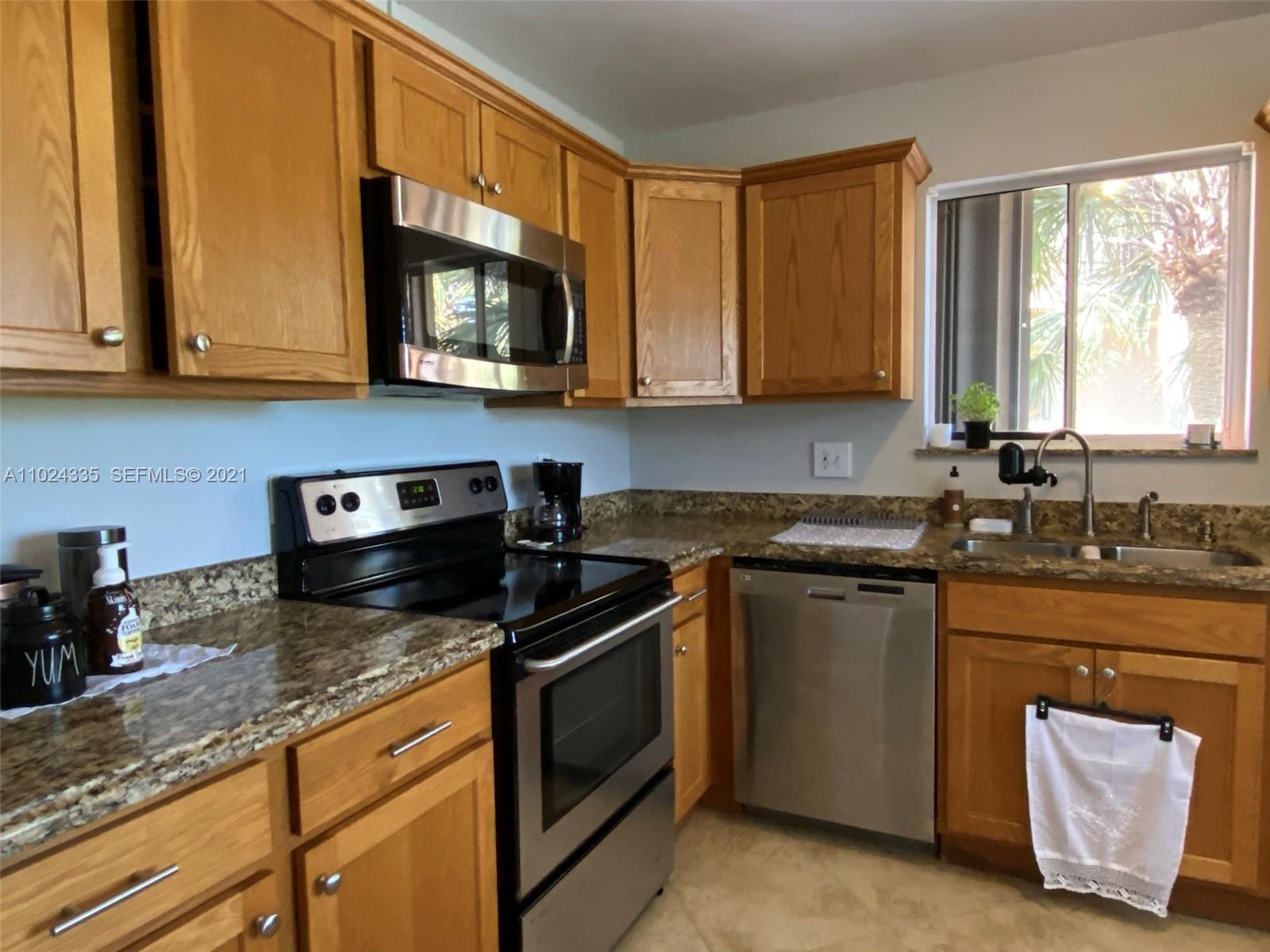 209 Lakeview Drive, Unit 202 Weston, FL 33326 - Photo 18 of 25 a kitchen with stainless steel appliances granite countertop a sink stove and microwave