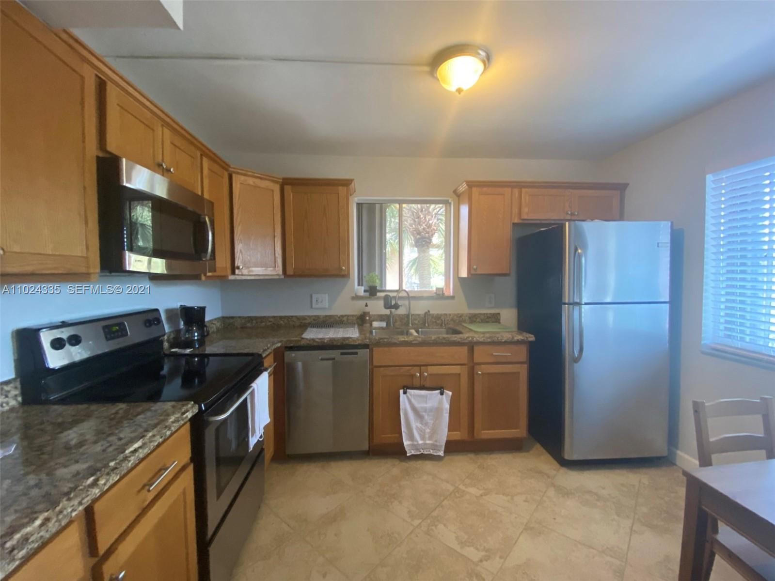 209 Lakeview Drive, Unit 202 Weston, FL 33326 - Photo 2 of 25 a kitchen with stainless steel appliances granite countertop a refrigerator a stove a sink and a microwave