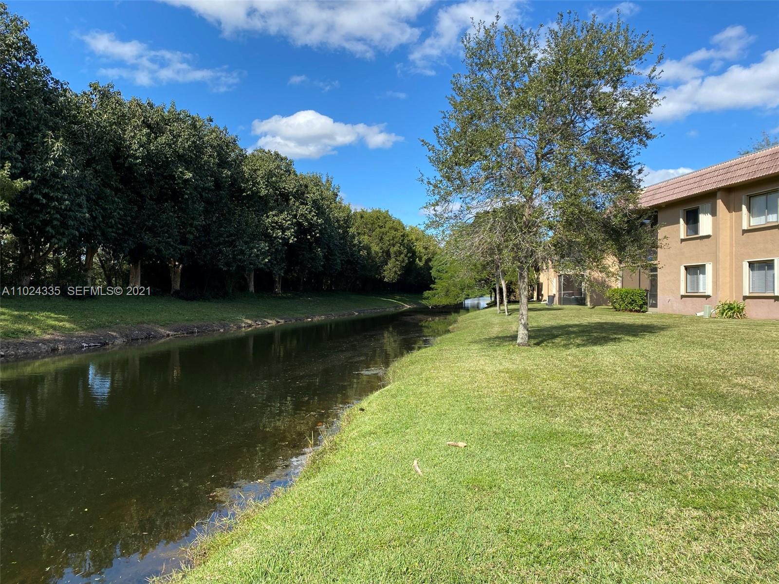 209 Lakeview Drive, Unit 202 Weston, FL 33326 - Photo 23 of 25 a view of a lake with a house in the background