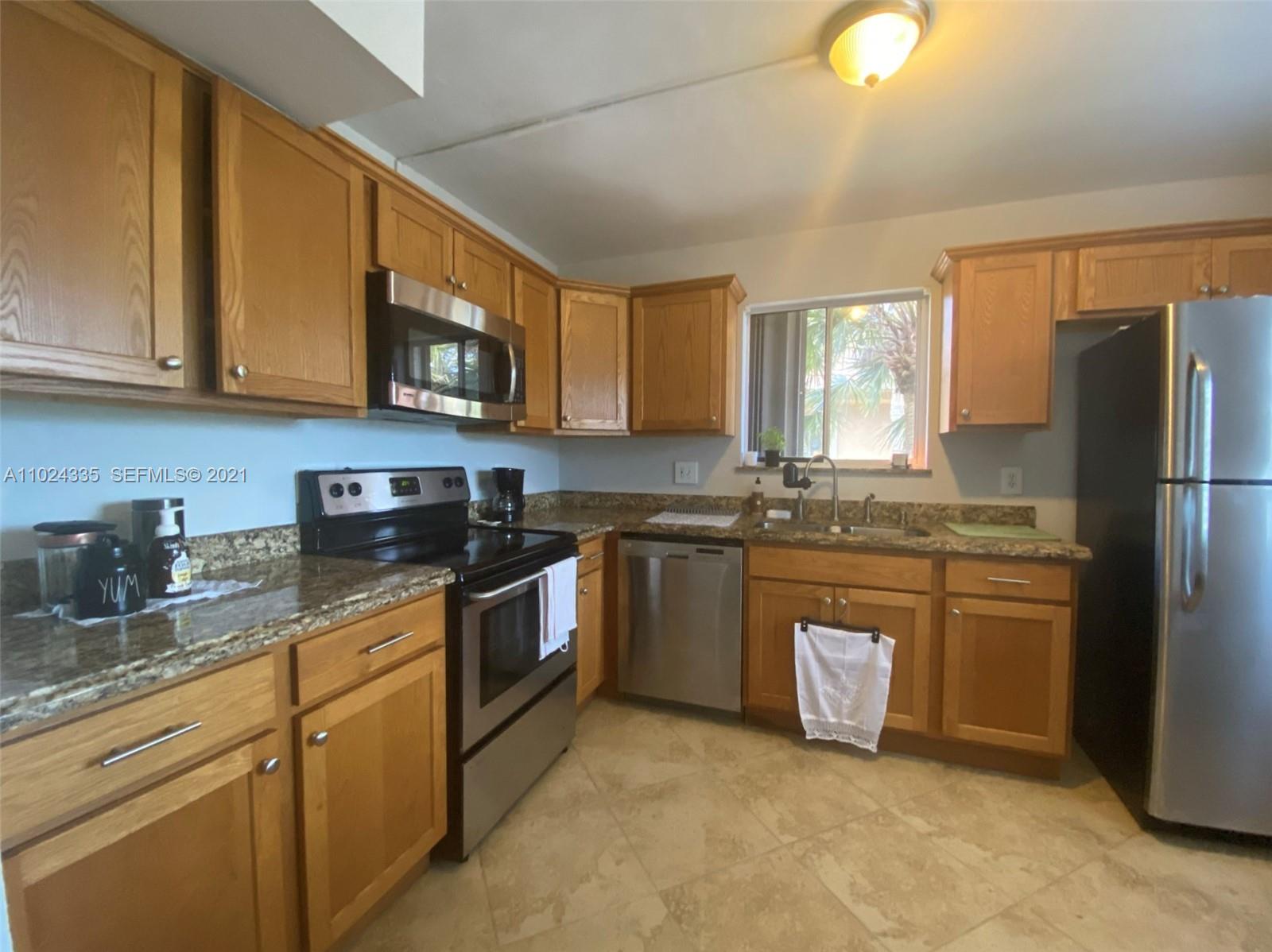 209 Lakeview Drive, Unit 202 Weston, FL 33326 - Photo 3 of 25 a kitchen with granite countertop a refrigerator stove top oven a sink and dishwasher
