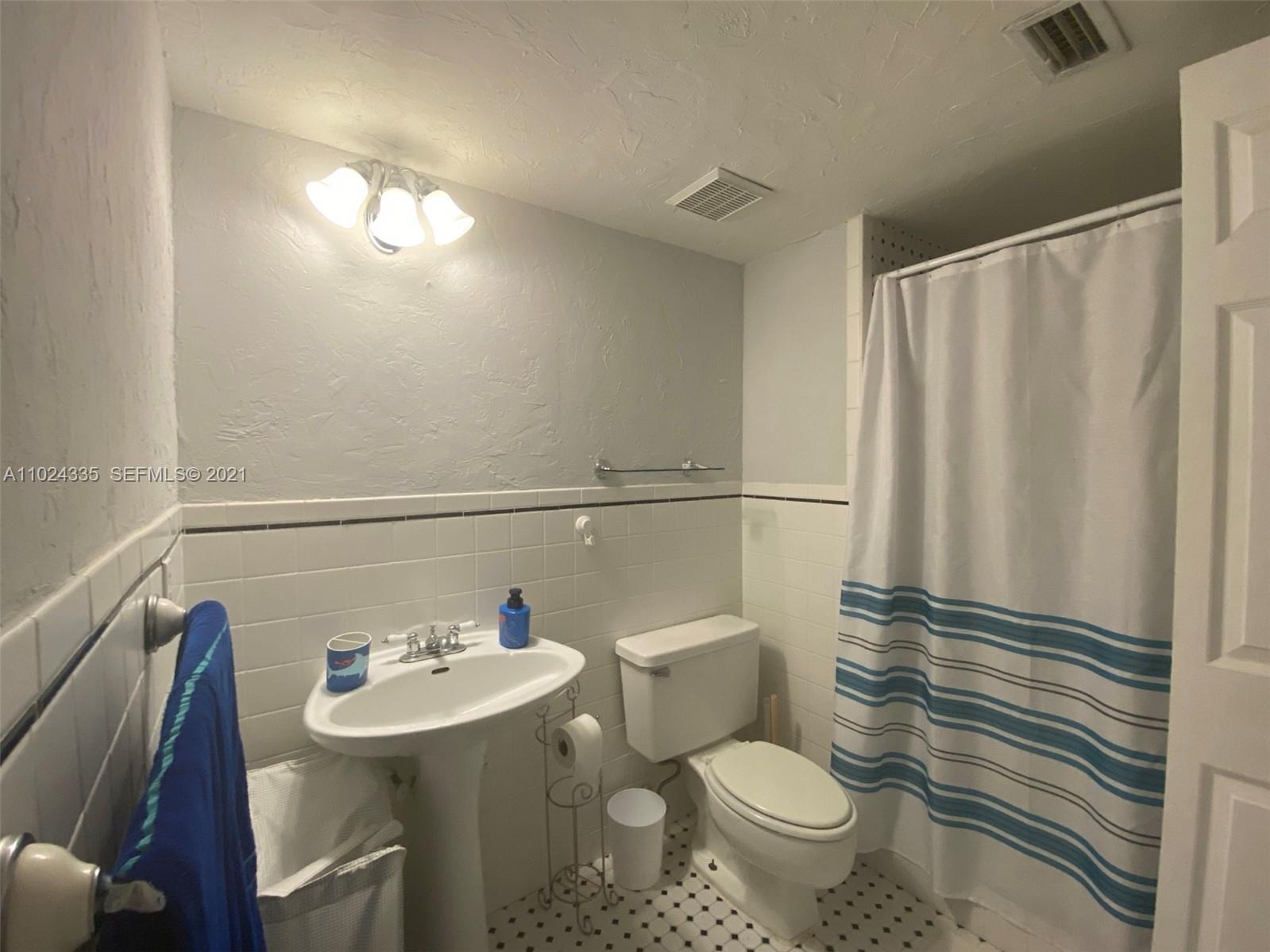209 Lakeview Drive, Unit 202 Weston, FL 33326 - Photo 5 of 25 a bathroom with a sink a toilet a mirror and shower curtain