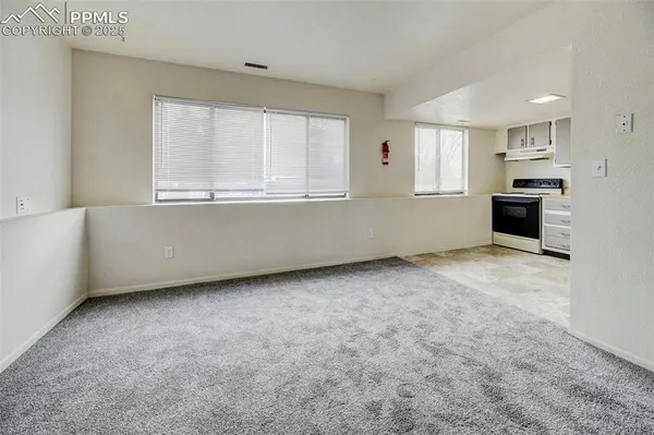 a living room with stainless steel appliances kitchen island granite countertop a stove a sink and a microwave
