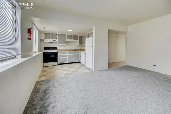 a large white kitchen with stainless steel appliances granite countertop a large counter top and a stove top oven