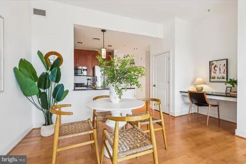 a living room with furniture a potted plant and a table