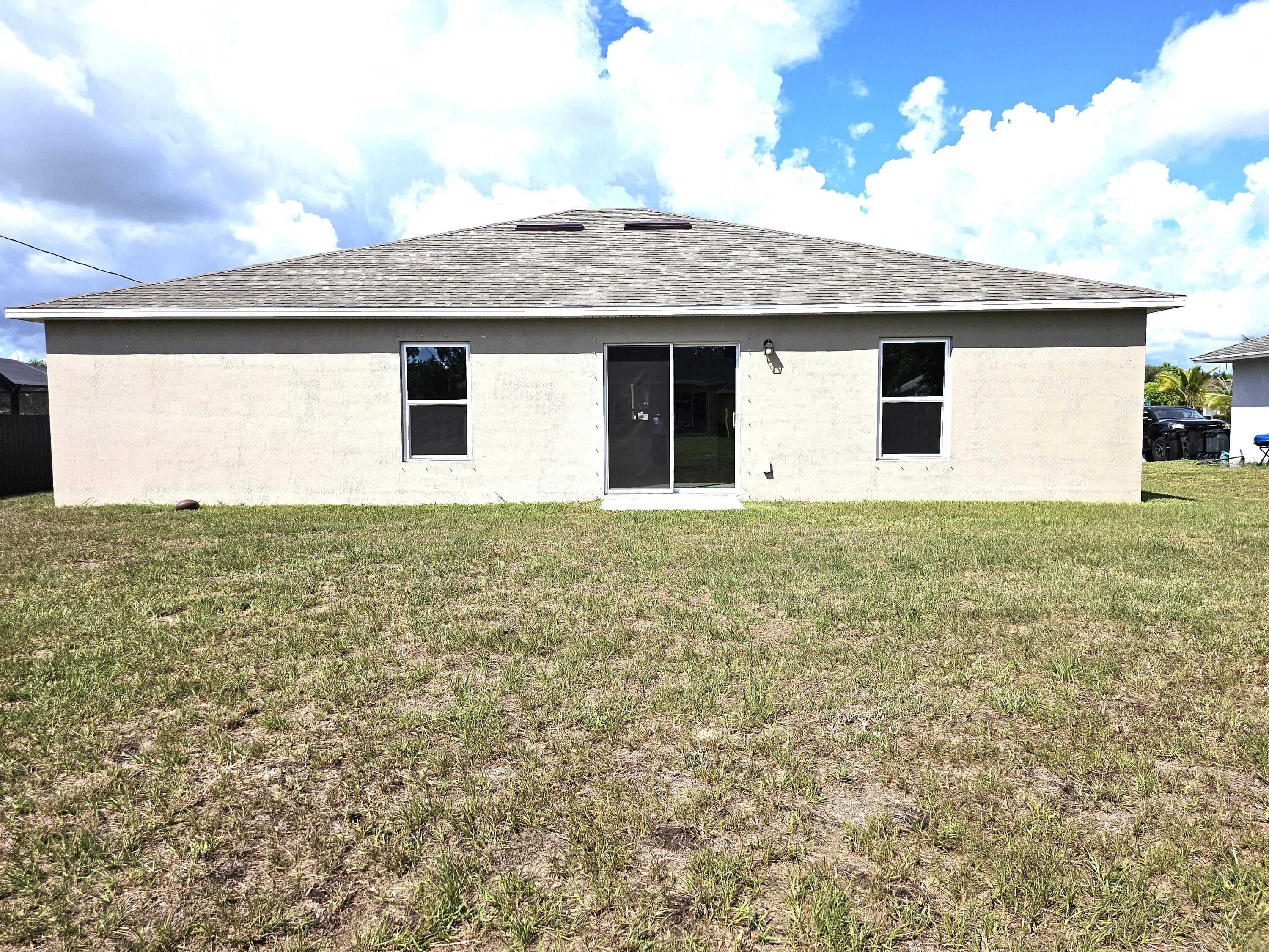 3681 Southwest Haines Street Port St. Lucie, FL 34953 - Photo 18 of 19 a view of a house with a yard