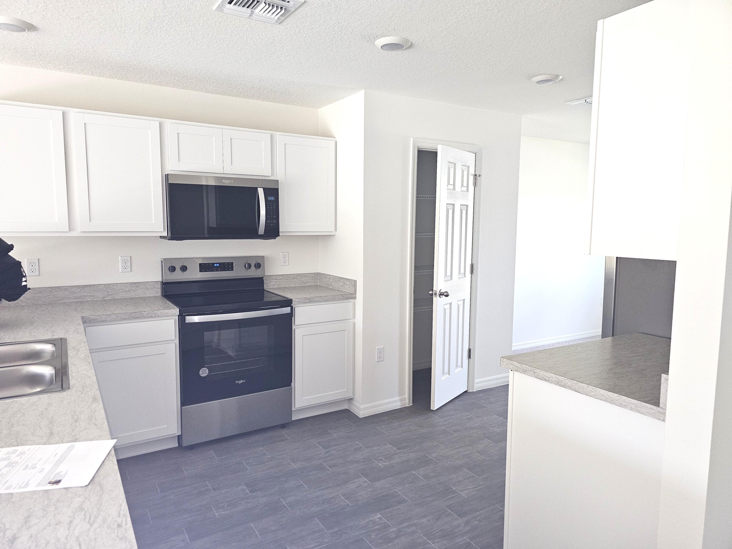 3681 Southwest Haines Street Port St. Lucie, FL 34953 - Photo 5 of 19 a kitchen with a refrigerator stove and microwave