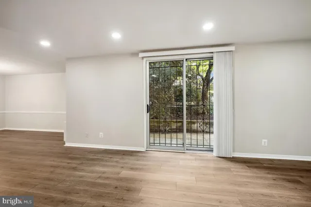 a view of a room with wooden floor and kitchen