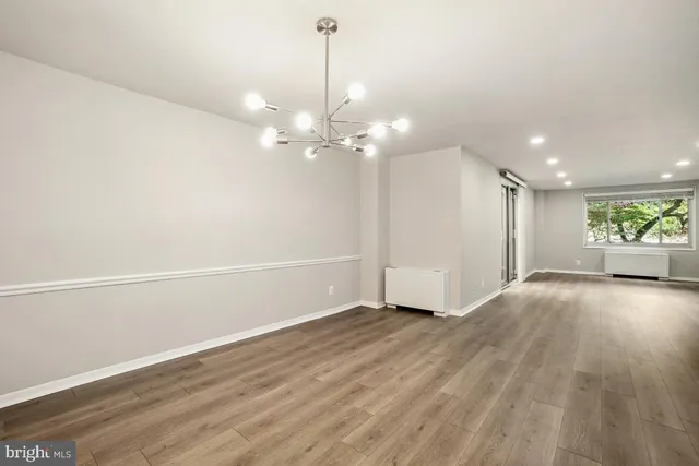 a view of a big room with wooden floor and windows