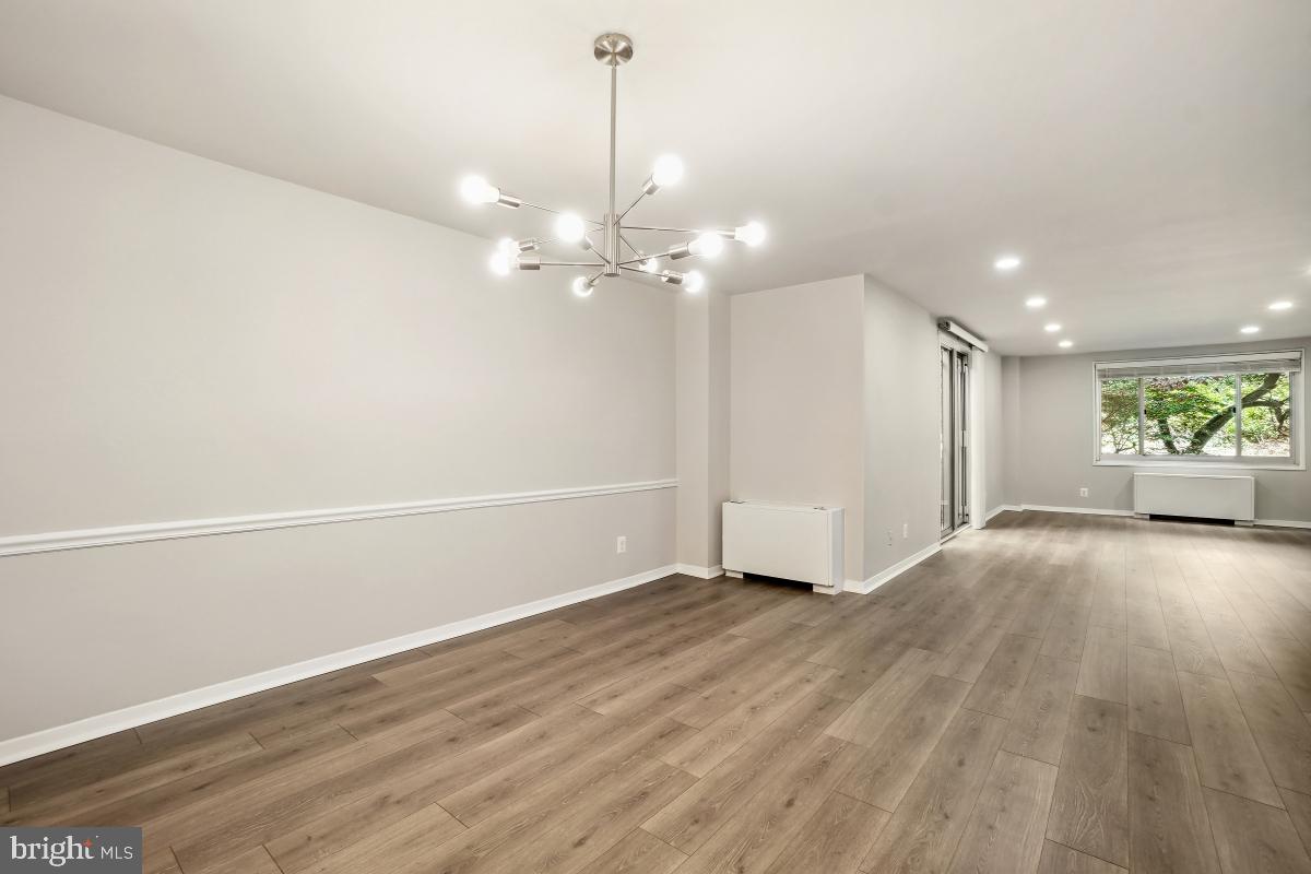1900 Lyttonsville Road, Unit 216 Silver Spring, MD 20910 - Photo 15 of 38 a view of an empty room with wooden floor and fan