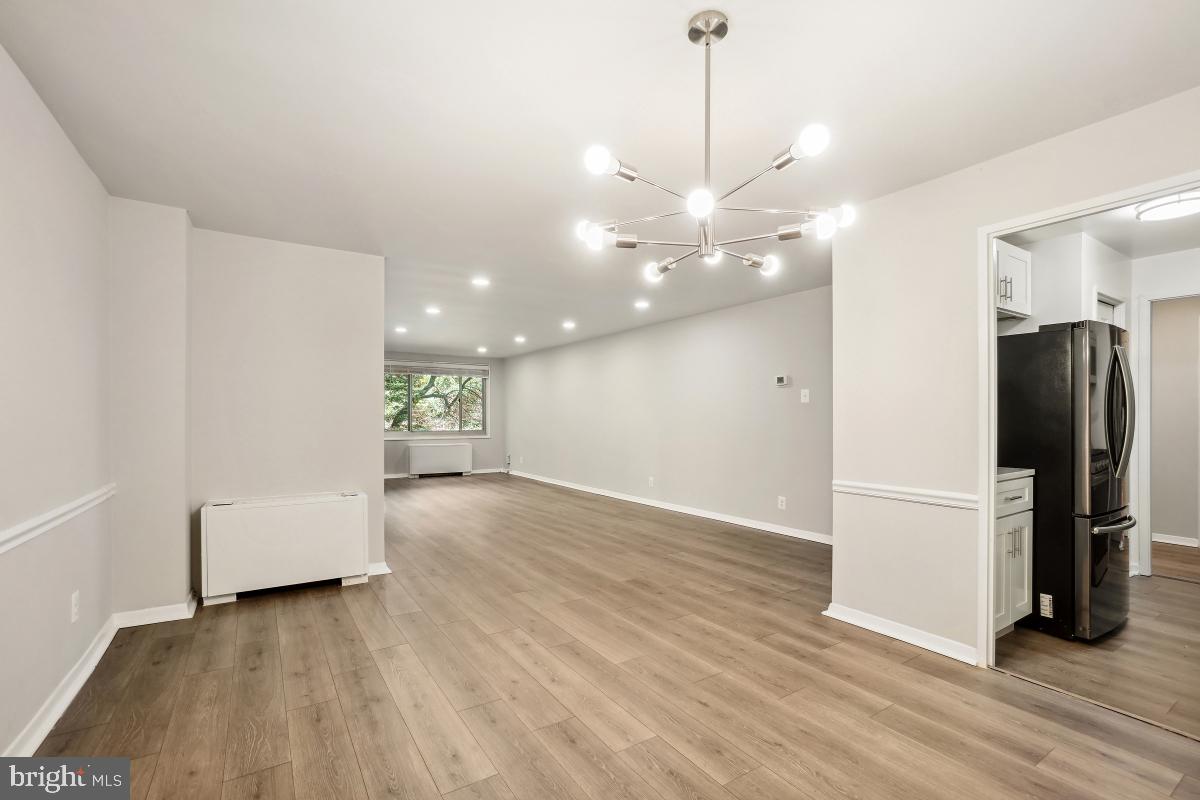 1900 Lyttonsville Road, Unit 216 Silver Spring, MD 20910 - Photo 16 of 38 a view of a big room with wooden floor and windows