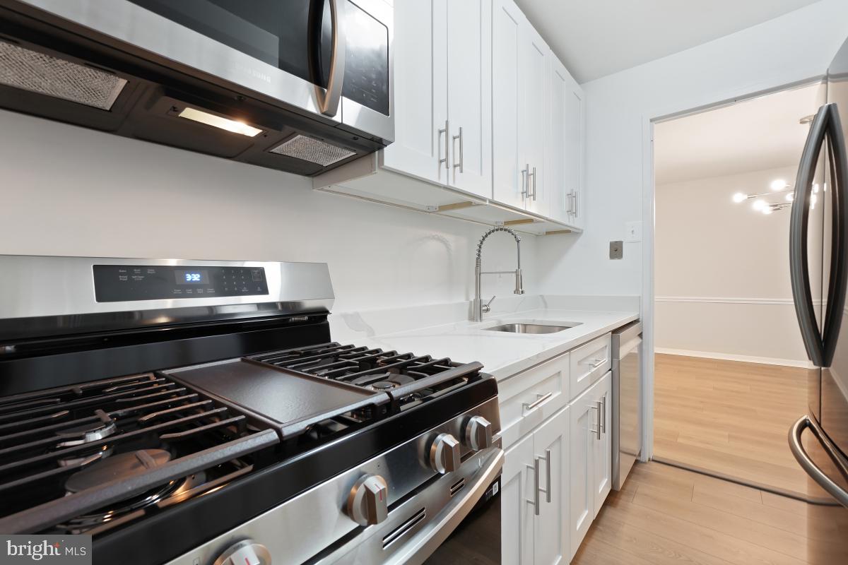 1900 Lyttonsville Road, Unit 216 Silver Spring, MD 20910 - Photo 18 of 38 a kitchen with a stove and a sink