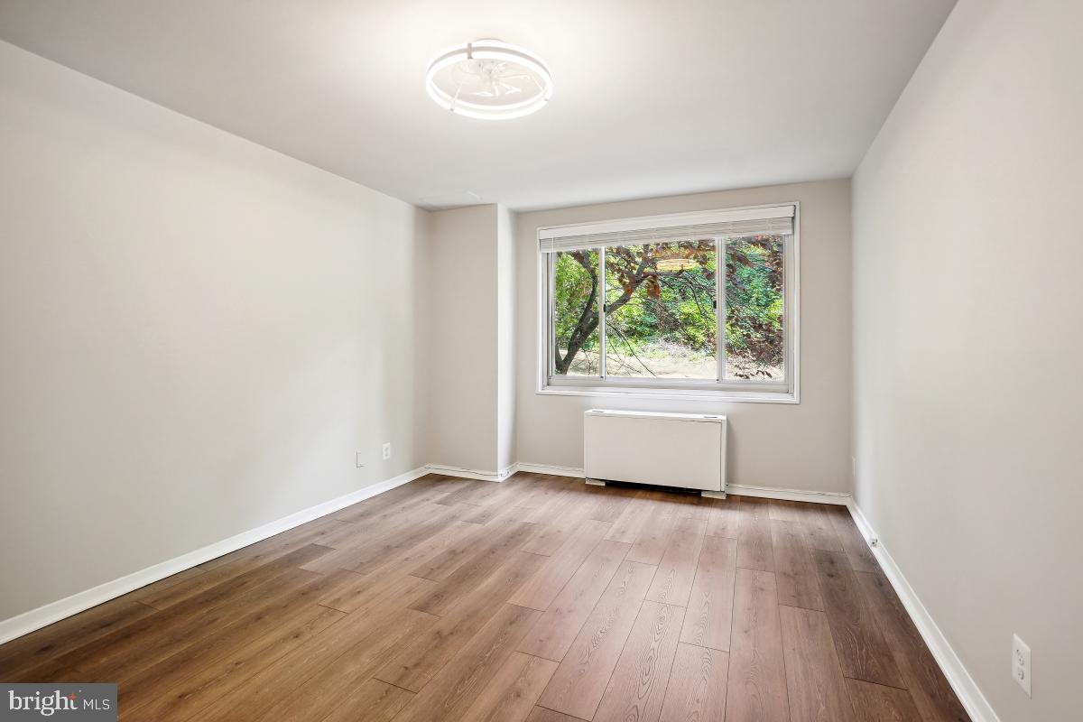 1900 Lyttonsville Road, Unit 216 Silver Spring, MD 20910 - Photo 23 of 38 an empty room with wooden floor and windows