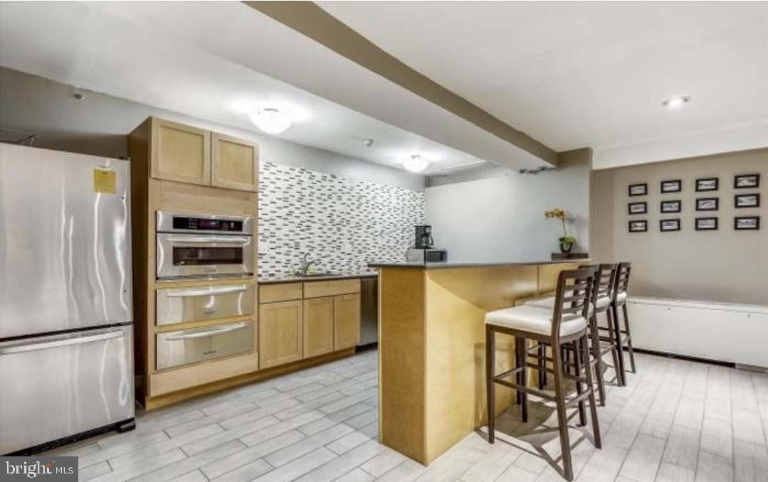 1900 Lyttonsville Road, Unit 216 Silver Spring, MD 20910 - Photo 30 of 38 a kitchen with cabinets and stainless steel appliances
