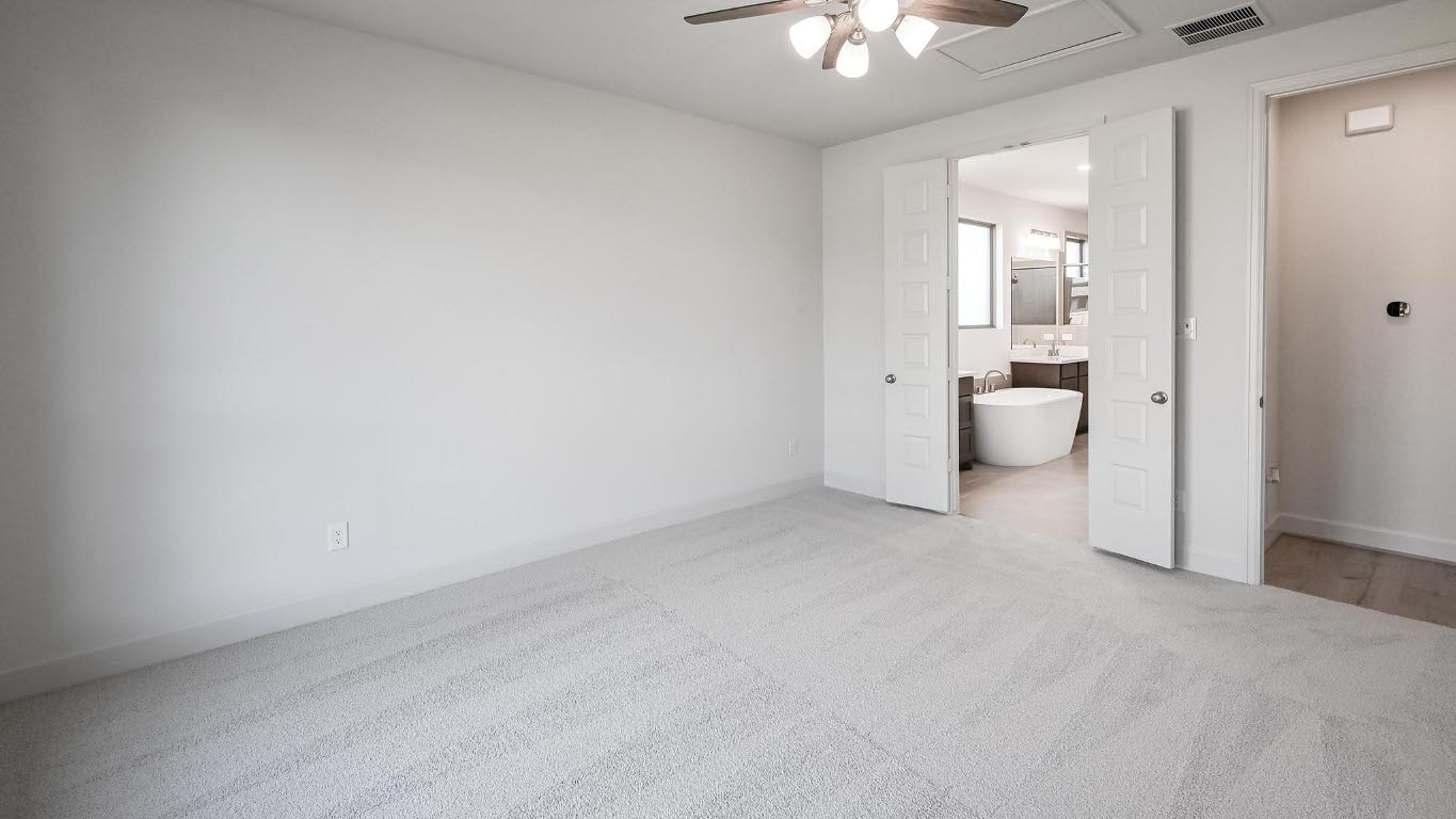 523 Prickly Poppy Loop Kyle, TX 78640 - Photo 19 of 40 Unfurnished bedroom featuring light carpet, ceiling fan, ensuite bathroom, and attic access