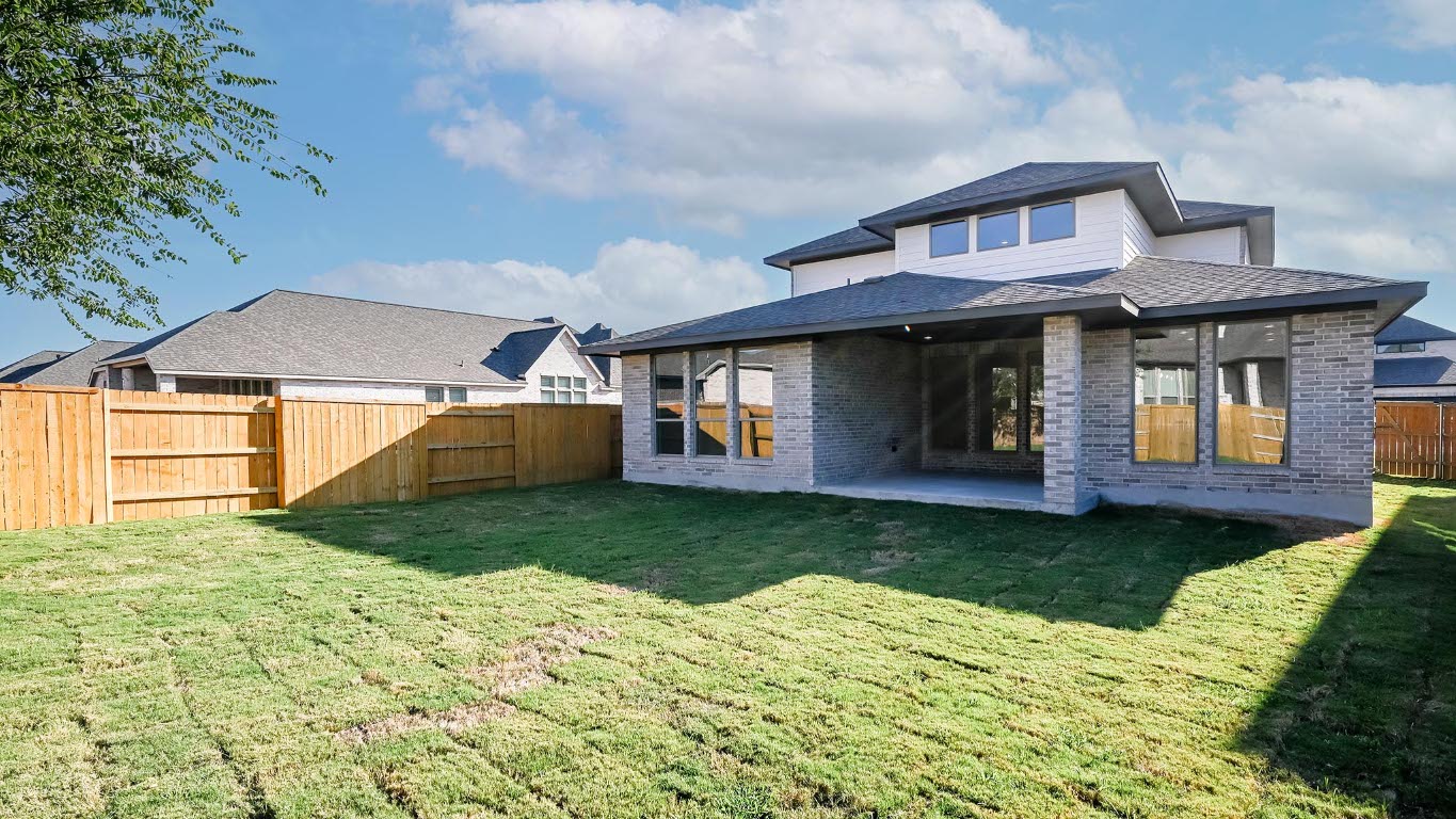 523 Prickly Poppy Loop Kyle, TX 78640 - Photo 25 of 40 Rear view of house with brick siding, a fenced backyard, and a patio area